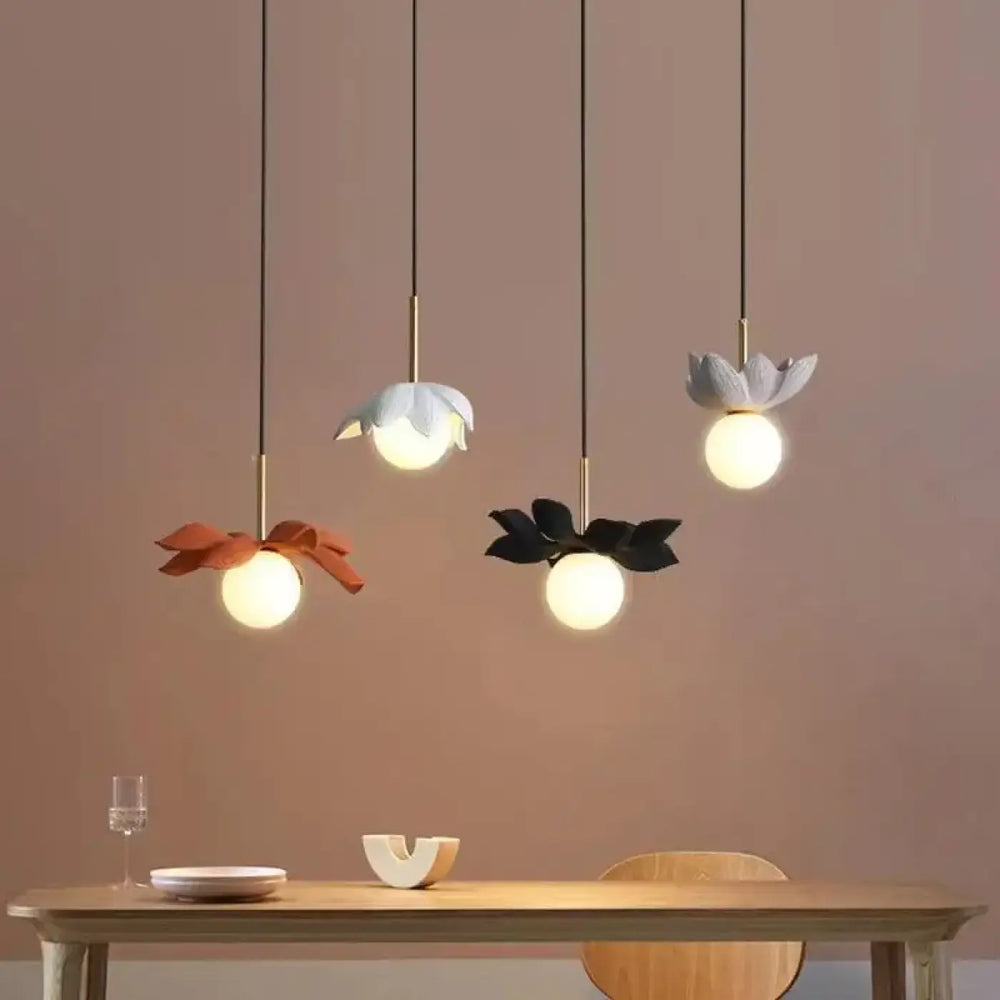 Suspension luminaire kalyx avec trois suspensions en céramique mate à motifs floraux et ampoules sphériques encastrées
