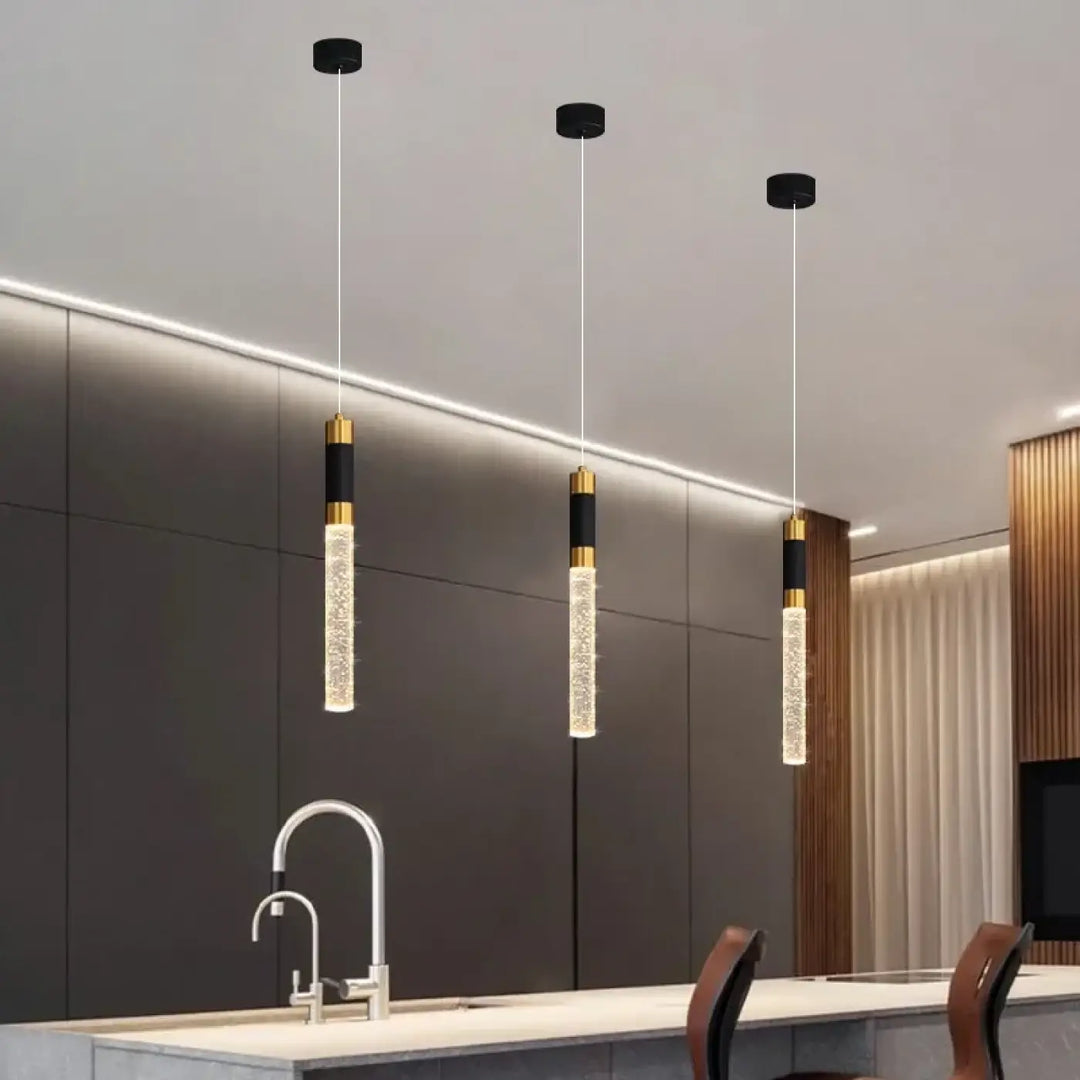 Suspension luminaire kairo avec effet bulles étincelantes en verre cylindrique et accents noir et or, émettant une lumière chaude