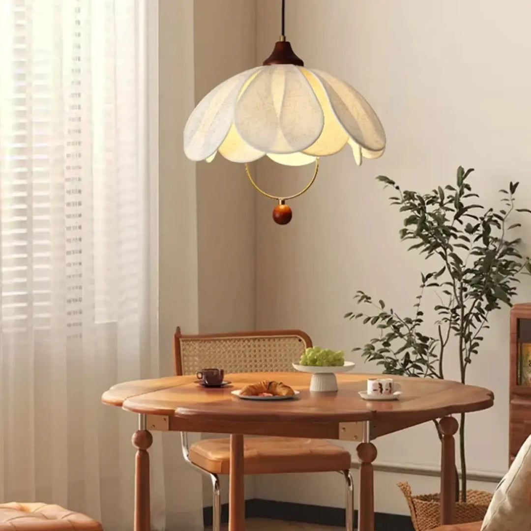 Suspension luminaire élégante perak en papier blanc avec détails dorés et bois suspendue au-dessus de la table à manger