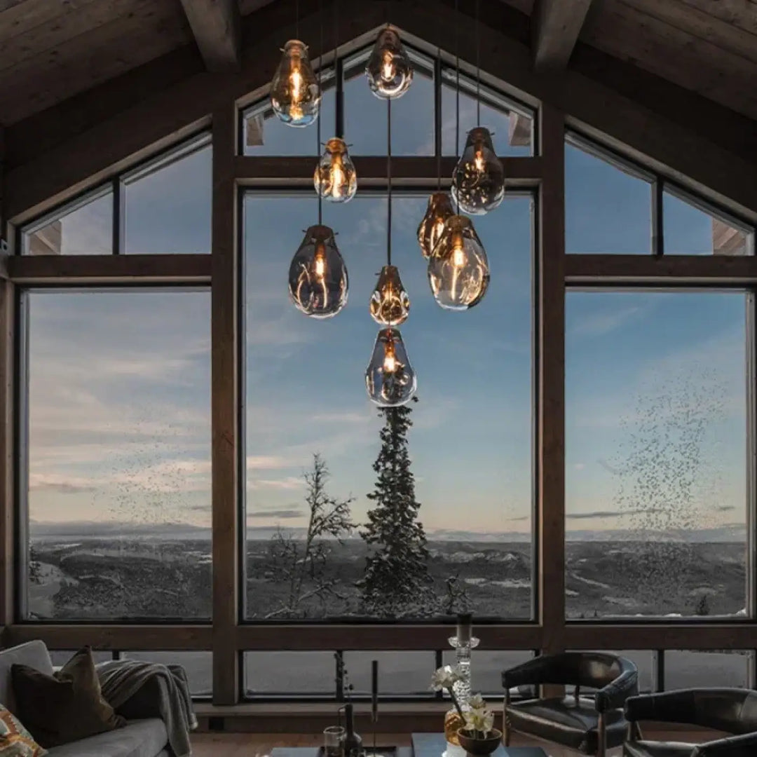 Un suspension luminaire vulco en verre avec ampoules filament exposées dans un agencement moderne aux tons chauds