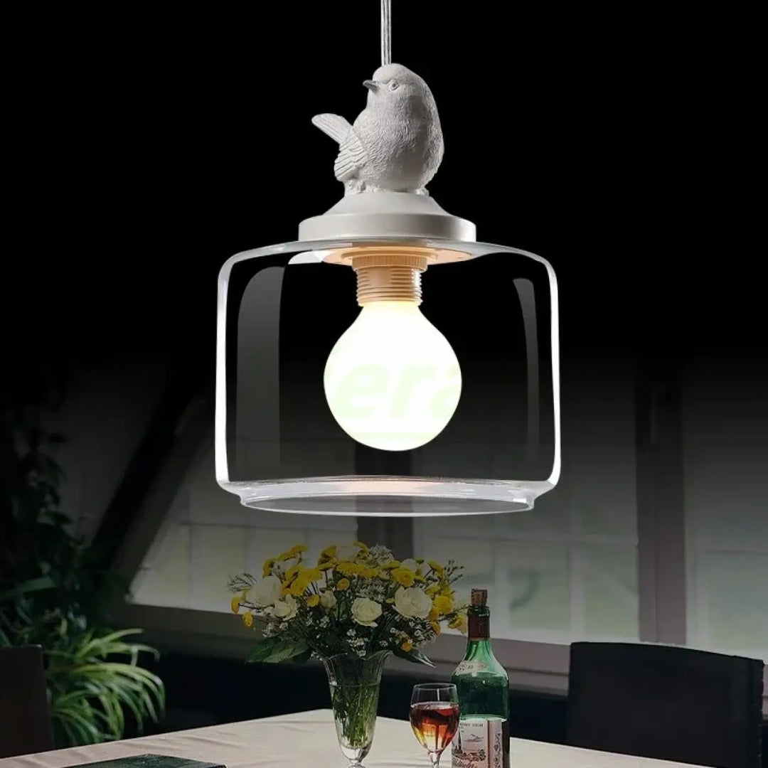 Luminaire plafonnier ornee avec suspension luminaire en verre transparent et oiseau en céramique blanche devient souvent presque sculpturale