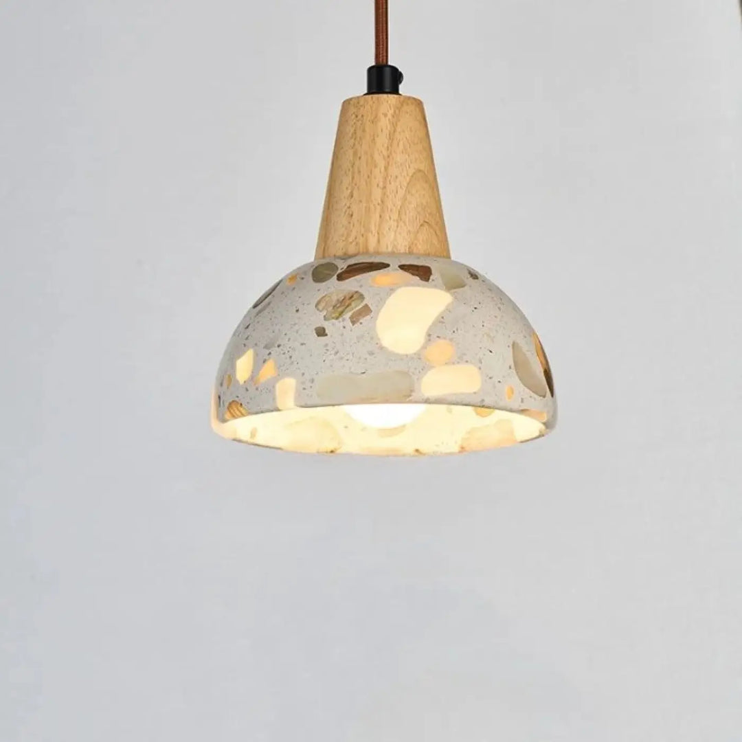 Suspension luminaire Tosca montre l’image d’une lampe suspendue moderne avec top en bois et abat-jour en terrazzo ajustable