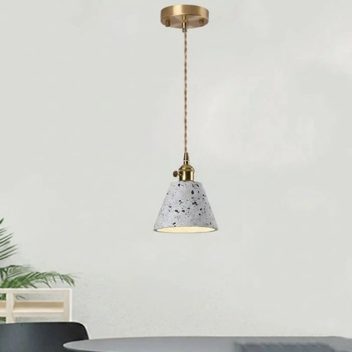 Montre l’image suspension luminaire tosça avec abat-jour en béton gris moucheté et accents en laiton chaîne cordon réglable