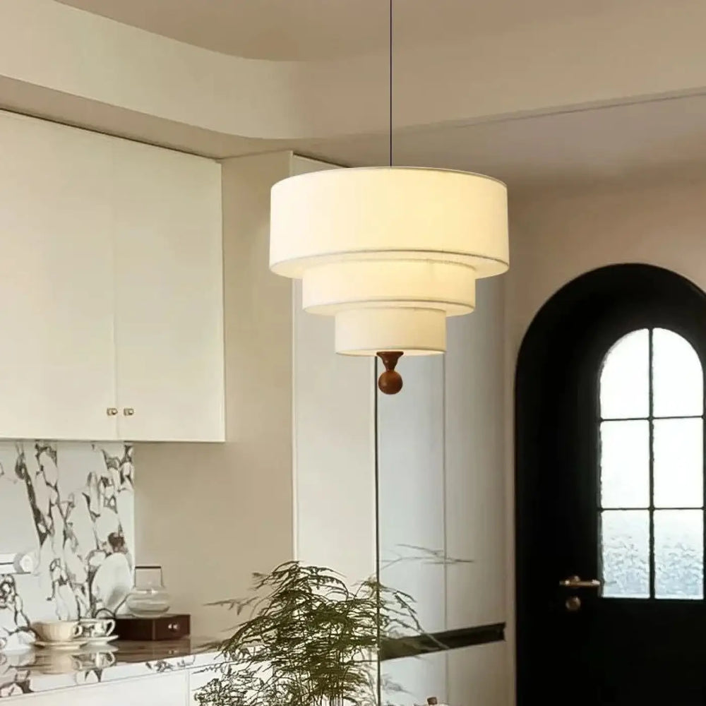 Suspension luminaire kyoto avec trois abat-jours concentriques en tissu blanc et un fleuron en bois foncé pour lumière douce