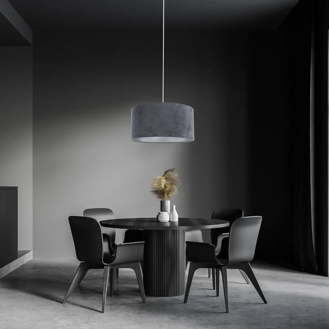 Suspension luminaire cylindrique avec abat-jour en velours tissu graphite suspendue au-dessus d’une table