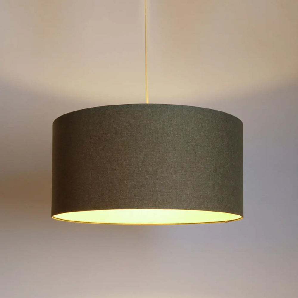 Suspension luminaire boho elegant vert gris avec abat-jour cylindrique tissu vert texturé intérieur jaune chaud