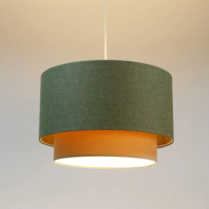 Suspension luminaire duo boho elegant avec abat-jour vert gris texturé et intérieur orange chaud suspendu par câble blanc fin
