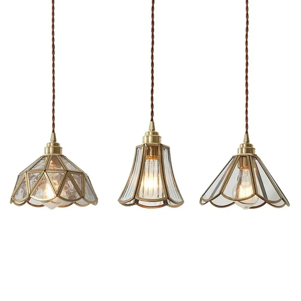 Suspension luminaire aureL avec trois luminaires en métal doré et verre cannelé géométrique clair suspendus par cordons torsadés