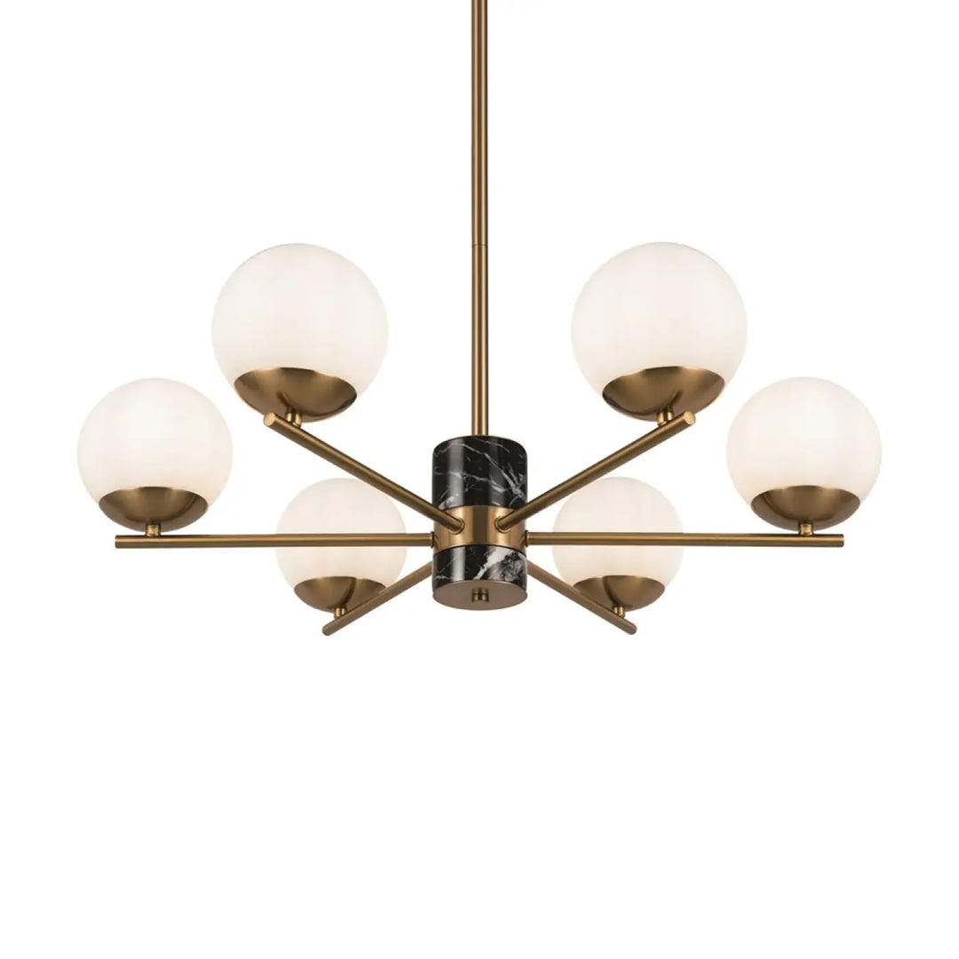 Suspension marble dorée avec six globes en verre dépoli et accent central en marbre noir au-dessus d’une pièce élégante