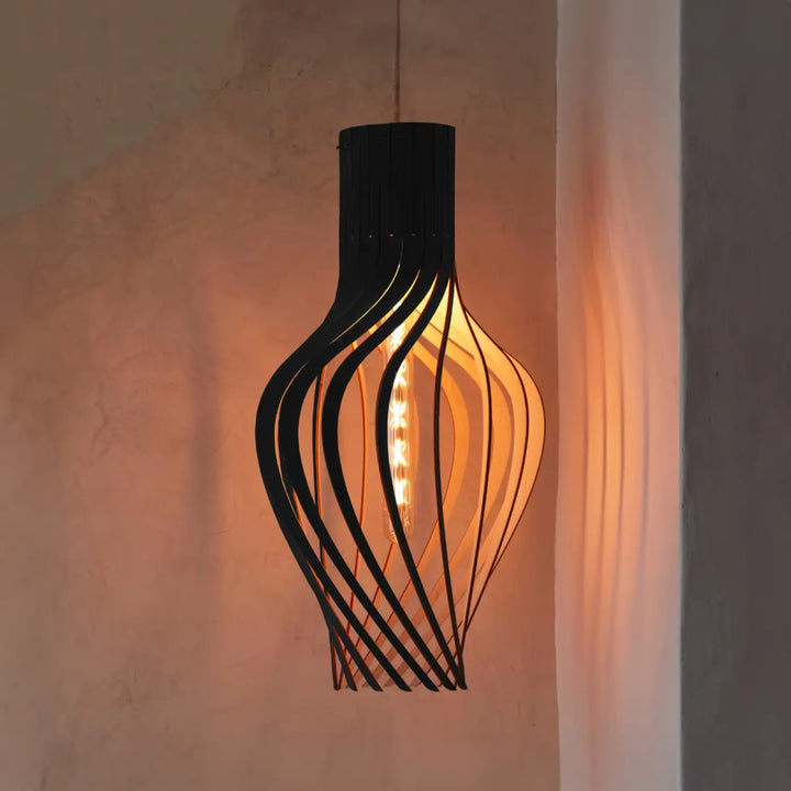 Suspension möntenyel piatoni en métal noir avec design torsadé et finition naturelle bois fsc éclaire dune lumière ambre chaude