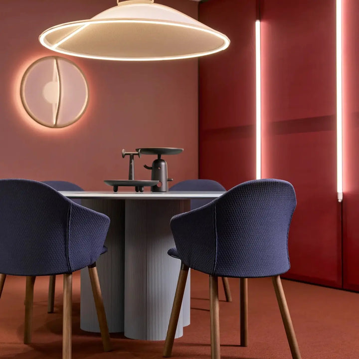 Modern navy blue woven fabric dining chairs with slender wooden legs complement lumière douce pendant by patricia urquiola tricot tendu