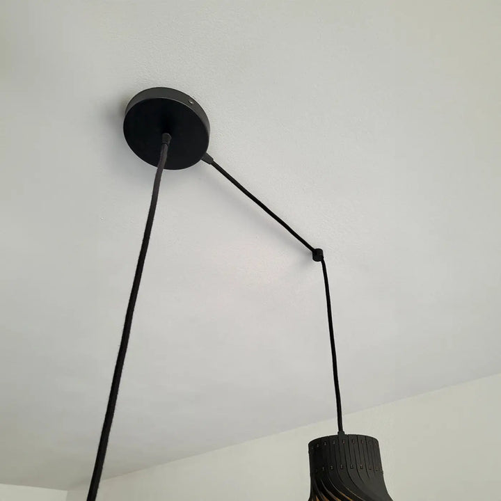 Suspension luminaire rinoz piatoni noire avec montage circulaire et abat-jour cylindrique en matériau stratifié pour cage d’escalier