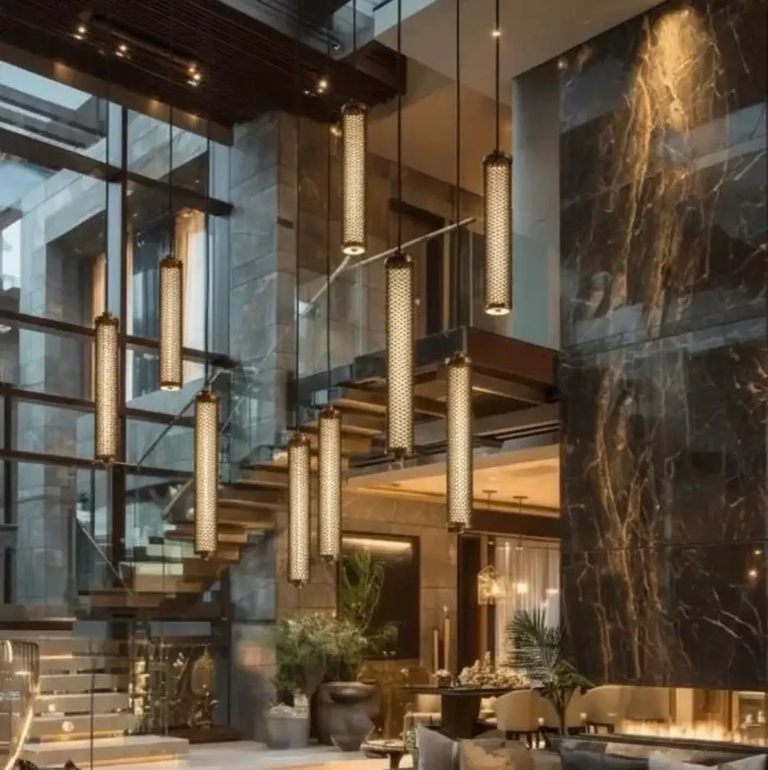 Modern cylindrical suspension tiffany verticale with warm golden glow and perforated metal mesh design hanging from ceiling