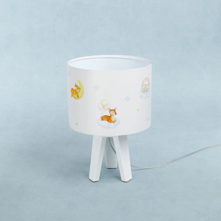 Lampe de table sweet dreams blanche avec abat-jour cylindrique illustré de cerf et lune sur pied trépied blanc