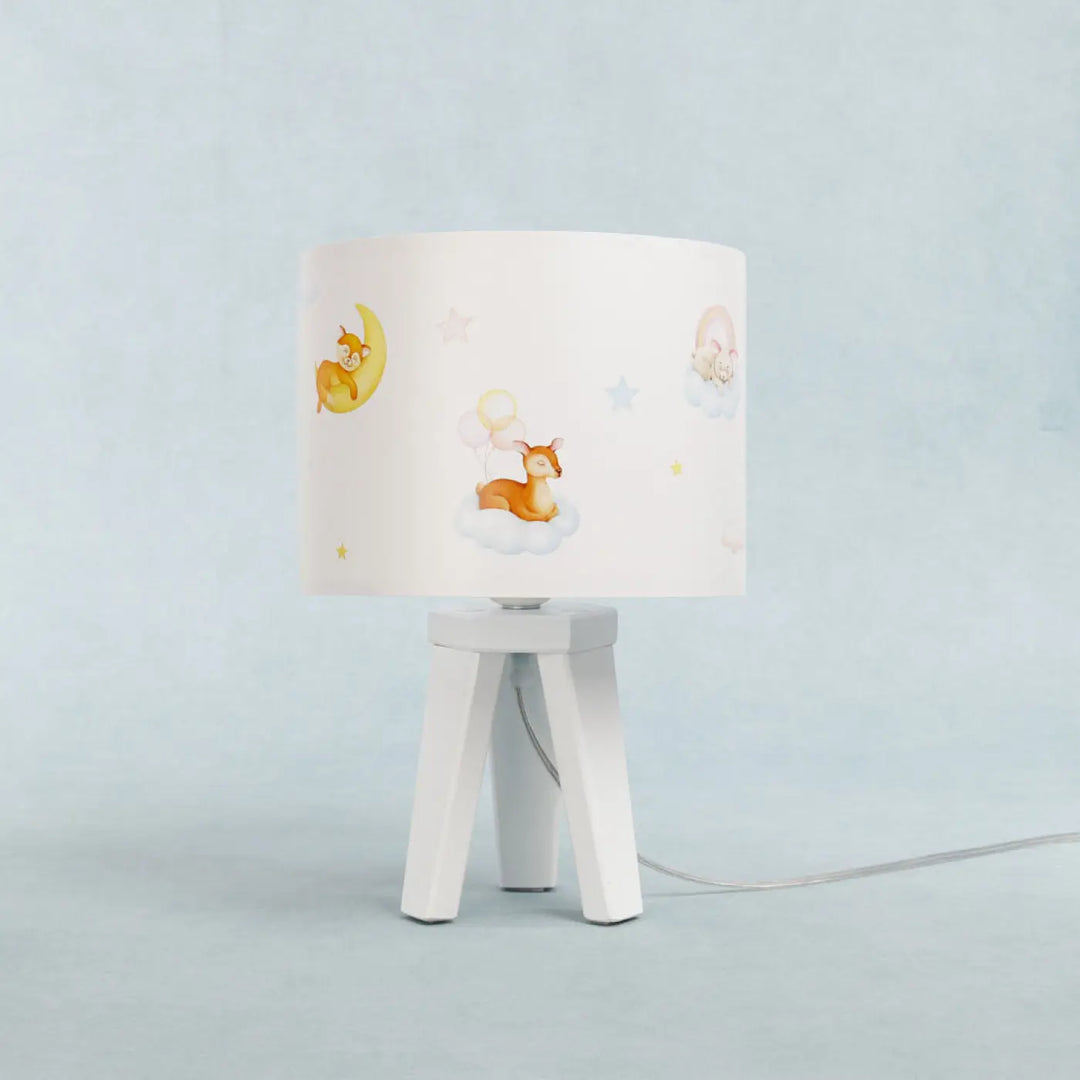 Lampe de table sweet dreams blanc avec abat-jour cylindrique illustré de cerfs lunes et étoiles sur pied trépied blanc