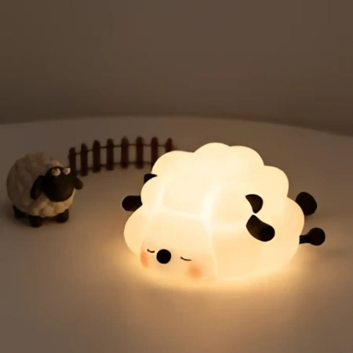 Veilleuse mouton cheepy en lumière douce blanche avec yeux et oreilles noirs, créant une présence lumineuse apaisante